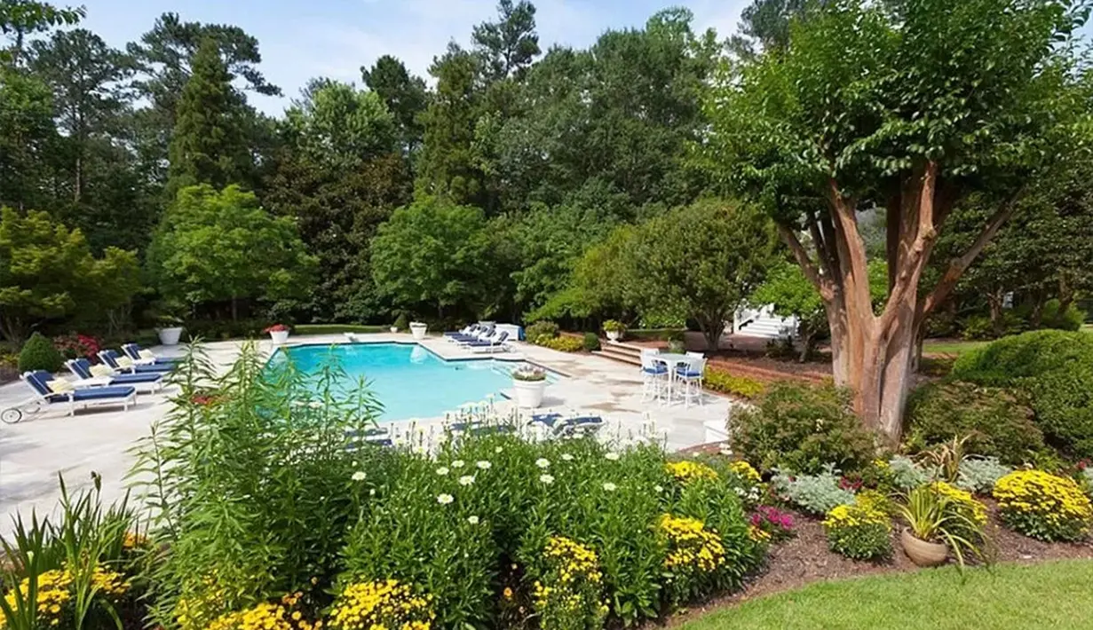 Tak ketinggalan kolam renang privat di ruang terbuka sebagai tempat berkumpul yang seru. Di sekeliling kolam terdapat taman-taman hijau yang asri. (Foto: via Zillow)