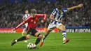 Pemain Manchester United, Alejandro Garnacho (kiri) berebut bola dengan pemain Real Sociedad, Nayef Aguerd dalam laga leg 1 babak 16 besar Liga Europa 2024/2025 di Anoeta Stadium, San Sebastian, Spanyol, Jumat (07/03/2025) dini hari WIB. (AP Photo/Miguel Oses)