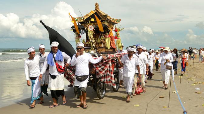 Iring-iringan umat Hindu Bali saat melakukan upacara Melasti di pantai Petitenget, Bali, Rabu (14/3). Dibeberapa kawasan seputaran Kota Denpasar terlihat umat Hindu berpakaian adat melakukan upacara Melasti. (AFP Photo/Sonny Tumbelaka)