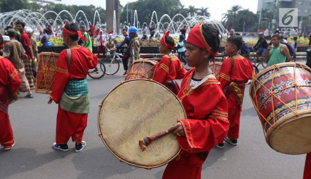Seniman cilik memainkan alat musik tambur khas Minangkabau saat car free day (CFD) di Jakarta, Minggu (13/1). Pertunjukan tersebut untuk mengenalkan alat musik tradisional Nusantara kepada masyarakat. (Liputan6.com/Angga Yuniar)