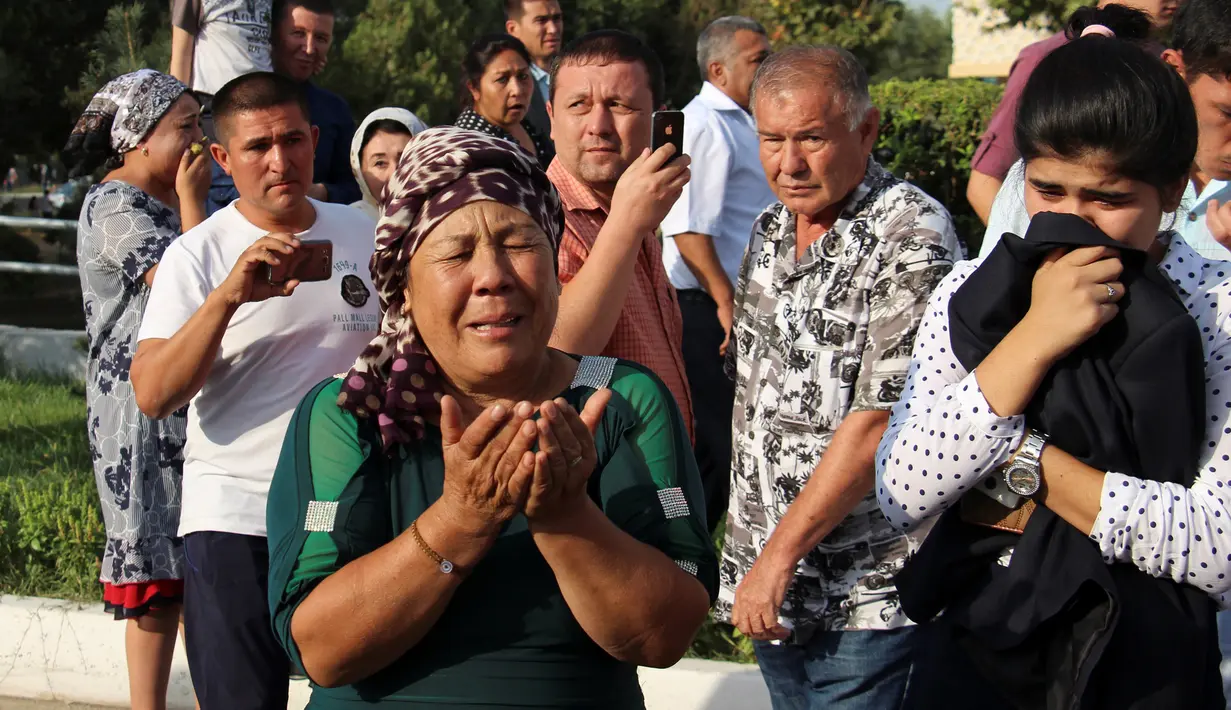 Warga berdoa saat iring-iringan mobil jenazah Presiden Uzbekistan, Islam Karimov di Tashkent, Uzbekistan, (3/9). Islam Karimov meninggal dunia pada usia 78 tahun. Mendiang telah memimpin Uzbekistan selama 27 tahun. (REUTERS/Muhammadsharif Mamatkulov)