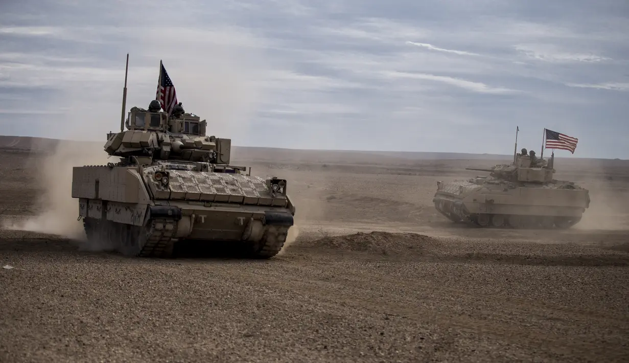 Tentara Amerika mengendarai kendaraan tempur Bradley selama latihan bersama dengan Pasukan Demokrat Suriah di pedesaan Deir Ezzor di timur laut Suriah, Rabu (8/12/2021). Puluhan tentara Amerika dan Pasukan Demokrat Suriah berpartisipasi dalam latihan bersama satu hari.  (AP Photo/Baderkhan Ahmad)