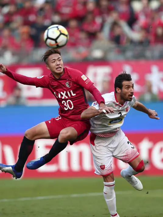 Striker Kashima Antlers, Hiroki Abe berebut bola udara dengan bek Persepolis Shojae Khalilzadeh selama pertandingan final Liga Champions AFC di Kashima pada 3 November 2018. Abe telah menuntaskan tes medis bersama Barcelona pada Senin (15/7/2019). (AFP Photo/Behrouz Mehri)