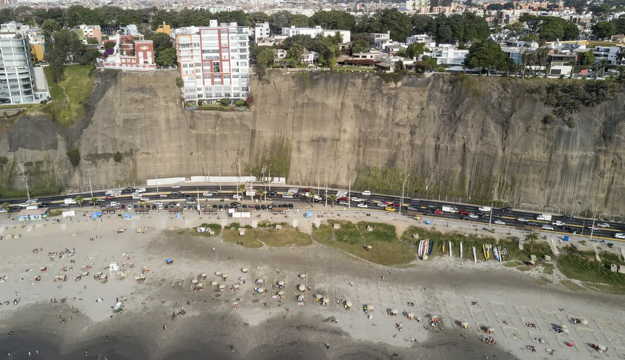 Para pengunjung berjemur dalam pembatas untuk menghindari keramaian di tengah pandemi COVID-19 di Pantai Lima, Peru, Rabu (21/12/2021). Di pantai-pantai populer di Lima, pihak berwenang memutuskan membuat pembatas untuk mencegah kerumunan pengunjung. (Ernesto BENAVIDES/AFP)