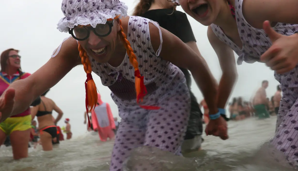 Warga Belgia menyerbu perairan Laut Utara untuk merayakan akhir pekan perrtama 2019 di Ostend, Sabtu (5/1). Cuaca dingin tidak menghalangi mereka menceburkan diri ke dalam air sebagai  tradisi tahun baru. (AP/Francisco Seco)