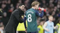 Pelatih Arsenal, Mikel Arteta, memberikan arahan kepada Martin Odegaard saat melawan Fulham pada laga pekan ke-20 Liga Inggris 2023/2024 di Craven Cottage, Minggu (31/12/2023). (AP Photo/Alastair Grant)