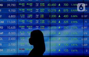 Karyawan melintasi layar pergerakan IHSG, Jakarta, Rabu (3/8/2022). Indeks Harga Saham Gabungan (IHSG) pada perdagangan di Bursa Efek Indonesia, Rabu (3/08/2022), ditutup di level 7046,63. IHSG menguat 58,47 poin atau 0,0084 persen dari penutupan perdagangan sehari sebelumnya. (Liputan6.com/Angga Yuniar)