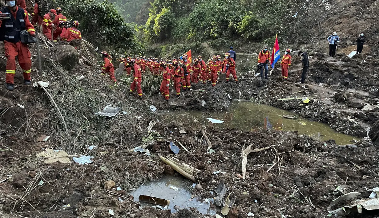 Tim penyelamat melakukan operasi pencarian di lokasi kecelakaan pesawat di Kabupaten Tengxian di Daerah Otonomi Guangxi Zhuang, China selatan (22/3/2022). Barang yang ditemukan ada berupa dompet bernoda lumpur, kartu bank dan Kartu identitas resmi. (Zhou Hua/Xinhua via AP)