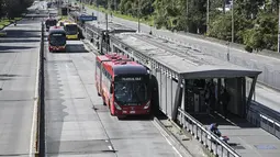 Bus angkutan umum melaju di jalan raya utama selama Car Free Day -hanya bus dan taksi yang diizinkan- di Bogota pada 2 Februari 2023. Kantor Wali Kota Bogota mengatakan acara ini berfungsi untuk "memiliki polusi (CO2) 57% lebih sedikit di lingkungan kita" karena hampir dua juta mobil pribadi dan setengah juta sepeda motor berhenti beredar. (Juan BARRETO / AFP)