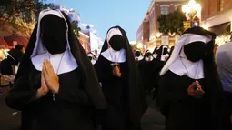 Wanita berpakaian biarawati berjalan sambil mempromosikan film 'The Nun' di luar San Diego Comic-Con, San Diego, California, Amerika Serikat, Kamis (19/7). (Mario Tama/Getty Images/AFP)