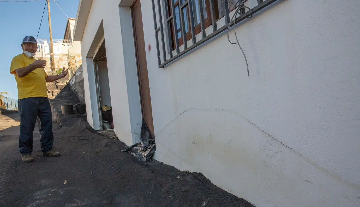 Seseorang menunjukkan kerusakan di rumahnya yang terletak di zona eksklusi menyusul letusan gunung berapi Cumbre Vieja, di lingkungan Las Manchas, Pulau La Palma, Spanyol pada 4 Januari 2022. Sekitar 1.000 orang diizinkan untuk pulang minggu ini, dari total 7.000 yang dievakuasi (DESIREE MARTIN/AFP)
