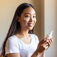 Ilustrasi perempuan mengaplikasikan sunscreen. Foto: Ilustrasi AI/Depositphotos.com