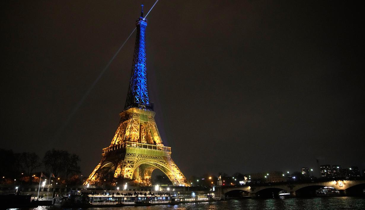 Menara Eiffel diterangi dengan warna bendera Ukraina untuk menandai peringatan satu tahun invasi Rusia ke negara itu di Paris, Prancis, 23 Januari 2023. (AP Photo/Christophe Ena)