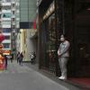 Seorang asisten toko yang mengenakan masker menunggu pelanggan di sebuah toko di Hong Kong, Jumat (28/1/2022). Hong Kong memangkas masa karantina wajib bagi orang-orang yang datang dari luar negeri dari 21 menjadi 14 hari. (AP Photo/Kin Cheung)