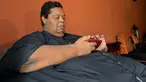 Oscar Vasquez Morales (44) memeriksa ponselnya di Palmira, Kolombia, 19 Maret 2016. Setelah selama berpuluh tahun mengonsumsi junk food, berat badan Oscar melonjak hingga 400 kilogram. (AFP PHOTO/Luis ROBAYO)