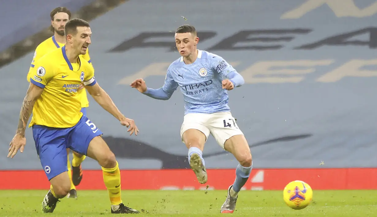 Pemain Manchester City Phil Foden (kanan) mencetak gol ke gawang Brighton and Hove Albion pada pertandingan Liga Inggris di Etihad Stadium, Manchester, Inggris, Rabu (13/1/2021). Manchester City menang 1.0. (Clive Brunskill /Pool via AP)