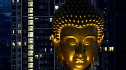 Patung Buddha raksasa setinggi 69 meter berdiri di kuil Wat Paknam Phasi Charoen di pinggiran Bangkok, Thailand pada Selasa (12/10/2021). Patung yang bernama "Phra Buddha Dhammakaya Thepmongkhon". tersebut terbuat dari tembaga lalu dicat warna emas. (Jack TAYLOR / AFP)