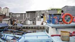 Seorang bocah melompat saat bermain di atas perahu di kawasan Luar Batang Jakarta, Selasa (14/11). Minimnya lahan bermain di kawasan tersebut membuat anak-anak memanfaatkan perahu yang bersandar untuk bermain. (Liputan6.com/Faizal Fanani)