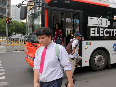 Warga berjalan dan turun dari bus Transjakarta di Jalan Jenderal Sudirman, Jakarta, Rabu (14/5/2025). (Liputan6.com/Herman Zakharia)