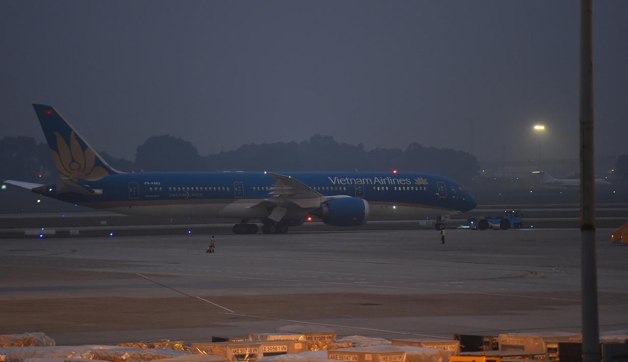 Pesawat Vietnam Airlines berisi belasan jenazah yang ditemukan tewas dalam truk kontainer di Inggris, tiba di bandara internasional Noi Bai, Hanoi, Rabu (27/11/2019). Begitu tiba di Vietnam, sebanyak 16 dari 39 jenazah dibawa ke kampung halaman mereka masing-masing dengan ambulans. (Nhac NGUYEN/AFP)