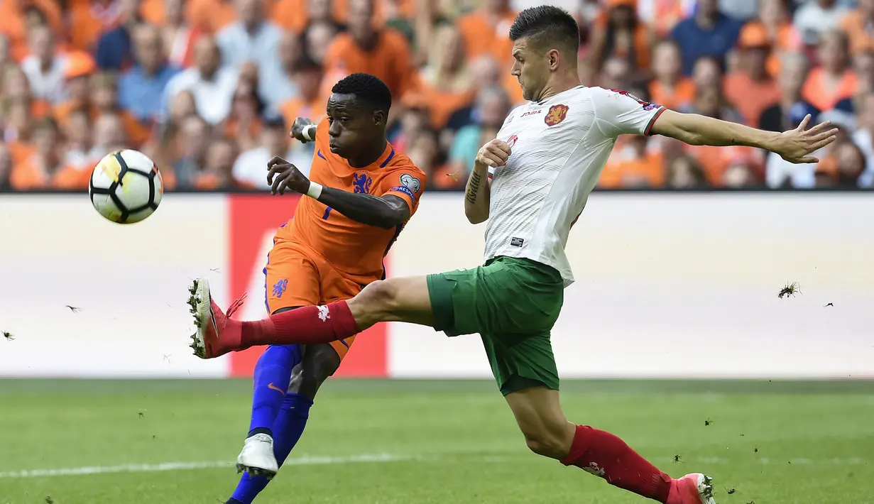 Pemain Belanda, Georgina Wijnaldum (kiri) melepaskan tembakan melewati adangan pemain Bulgaria, Strahil Popov pada laga grup A kualifikasi Piala Dunia 2018 di Amsterdam, (3/9/2017). Belanda menang 3-1. (AFP/John Thys)