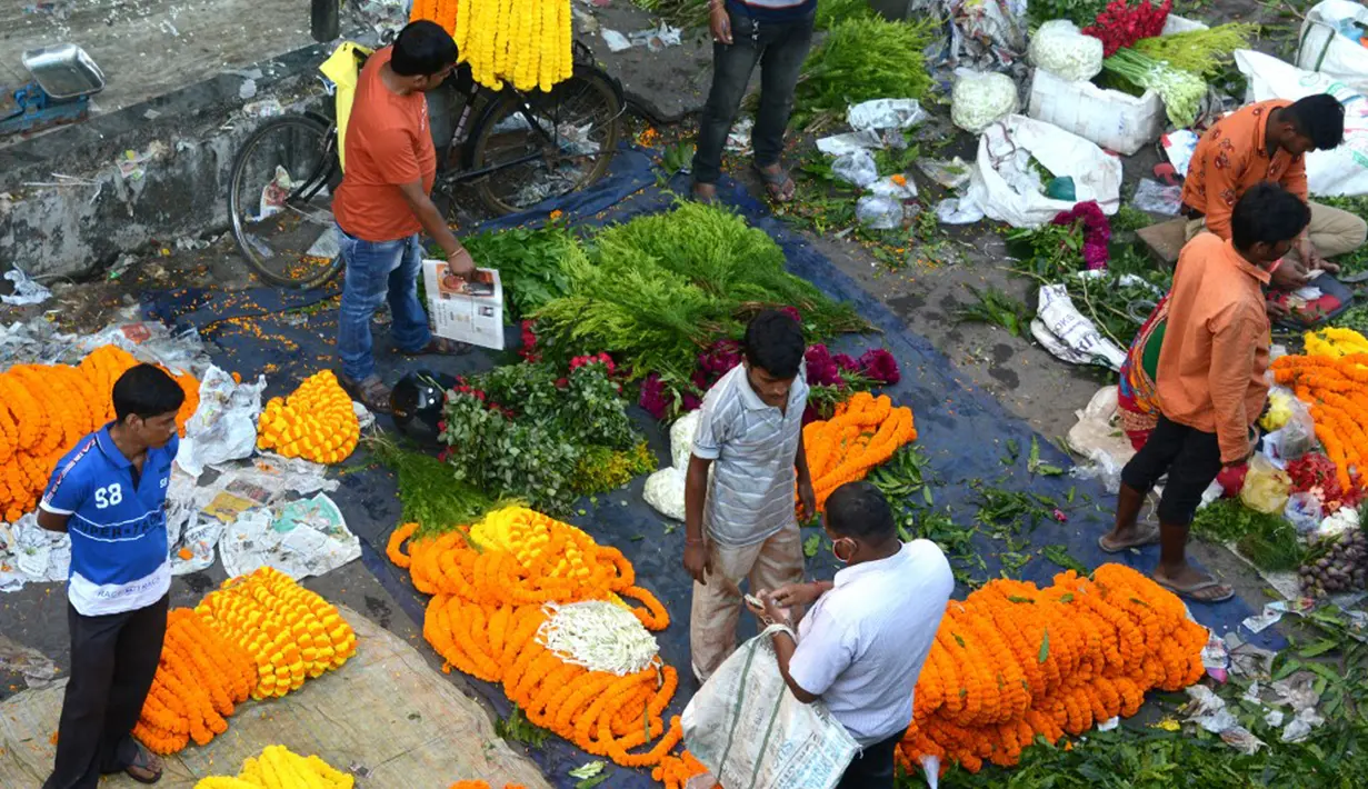 Para pedagang menjajakan bunga untuk dijual selama Festival Durga Puja di pinggir jalan Siliguri, India, Selasa (12/10/2021). Durga Puja juga disebut Durgotsab adalah festival tahunan di Asia Selatan untuk memuja dewi Durga dari agama Hindu. (DIPTENDU DUTTA/AFP)