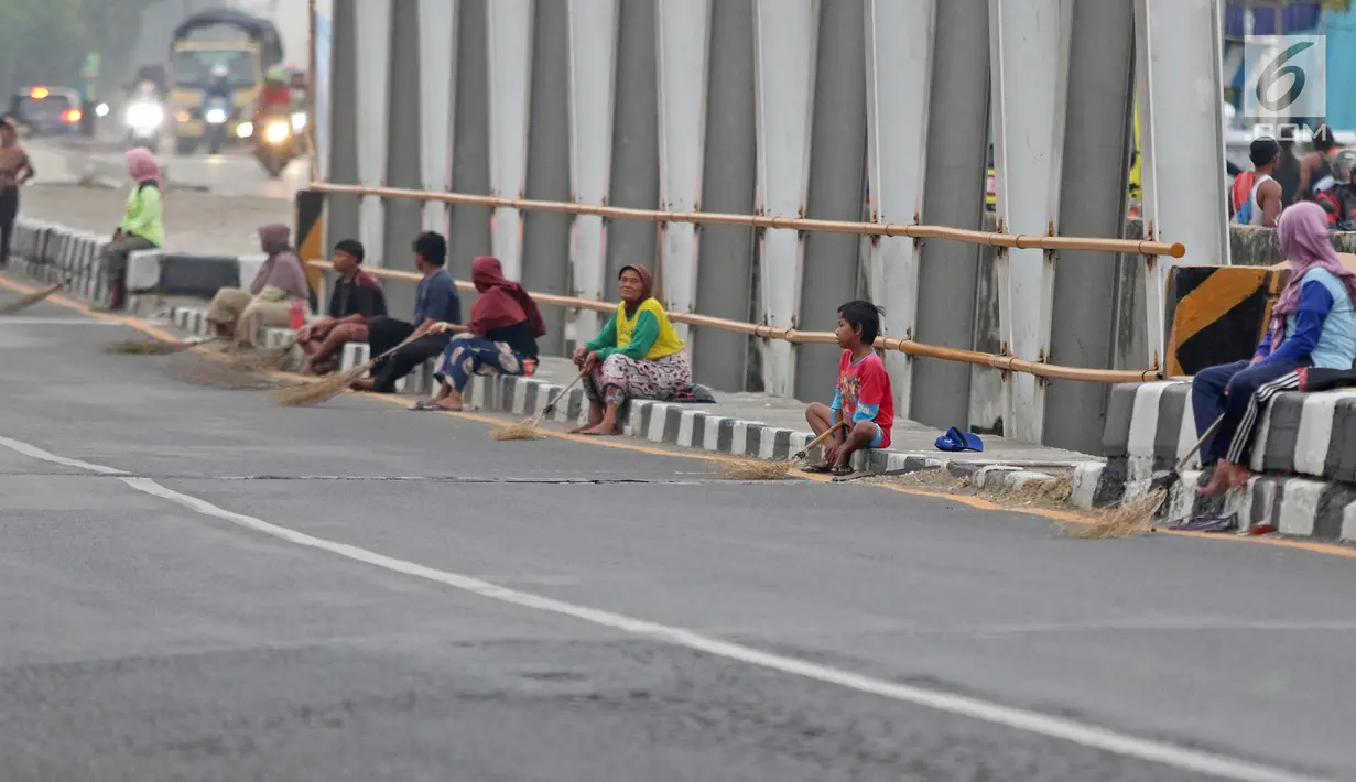 Warga membawa sapu menunggu pengguna jalan memberi sedekah dengan melempar uang di Jembatan Sewo, Jalur Pantura Sukra Indramayu, Jawa Barat, Senin (3/6/2019). Keberadaan pencari sedekah bisa membahayakan keselamatan pemudik serta pengguna jalan lainnya. (Liputan6.com/Herman Zakharia)