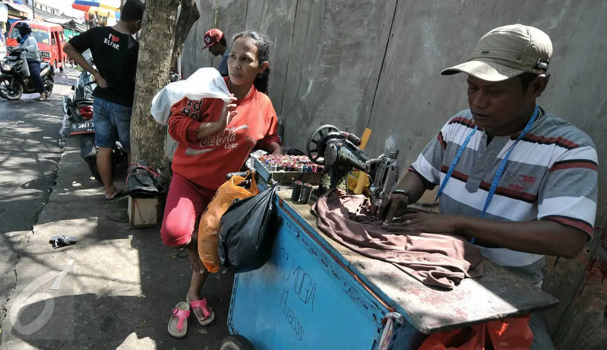 Penjahit keliling memperbaiki pakaian pesanan warga, Jakarta, Senin (4/7/2016). Menjelang hari raya Idul Fitri, penjahit 'vermak levis' keliling mulai kebanjiran rezeki. (Liputan6.com/Yoppy Renato)