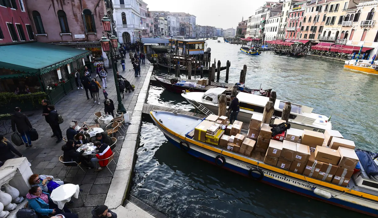 Sebuah kapal yang mengangkut barang berlabuh di dermaga Grand Canal di Venesia (4/11/2019). Kanal ini merupakan salah satu koridor lalu lintas air utama di Venesia. (AFP Photo/Miguel Medina)