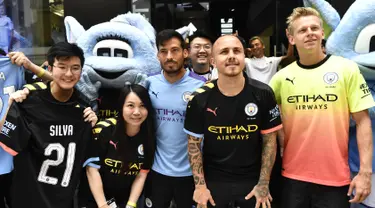 Pemain Manchester City David Silva, Angelino dan Oleksandr Zinchenko foto bersama dengan penggemar selama acara promosi di Hong Kong (23/7/2019). The Citizens akan menghadapi Kitchee SC dalam laga uji cobadi Hong Kong Stadium pada 24 Juli 2019. (AFP Photo/Anthony Wallace)