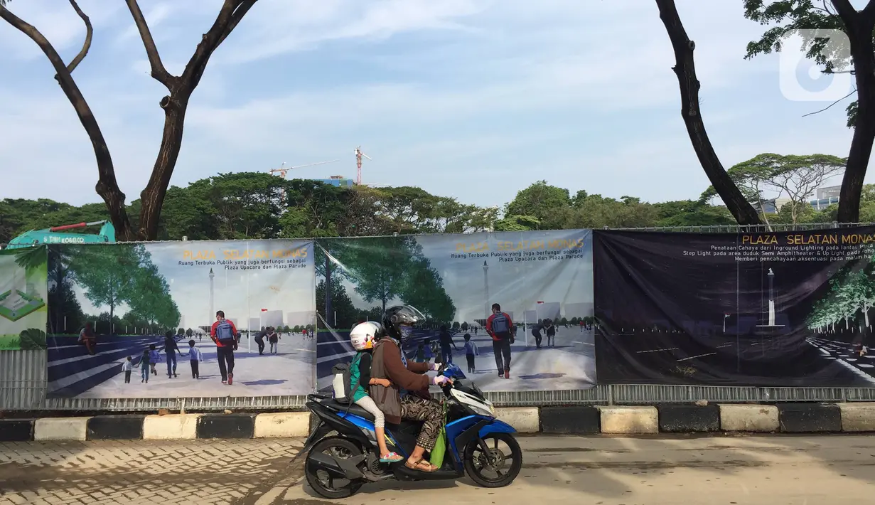 Pengendara sepeda motor melintas dekat pambangunan proyek revitalisasi Taman Monumen Nasional (Monas) di Jakarta, Sabtu (18/1/2020). Sejumlah fasilitas publik akan dibangun di Taman Monas, mulai dari lokasi upacara dan parade. (Liputan6.com/Immanuel Antonius)