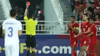 Wasit Shen Yinhao memberi kartu merah kepada kapten Timnas Indonesia U-23, Rizky Ridho (ketiga kanan) saat menghadapi Uzbekistan U-23 pada laga semifinal Piala Asia U-23 2024 di Abdullah bin Khalifa Stadium, Doha, Qatar, Senin (29/4/2024). (AFP/Karim Jaafar)