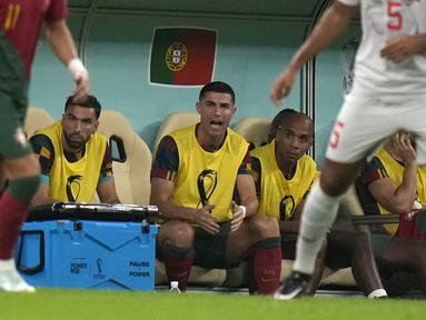 Ekspresi Cristiano Ronaldo (tengah) saat duduk di bangku cadangan selama pertandingan sepak bola babak 16 besar Piala Dunia 2022 di Stadion Lusail, Lusail, Qatar, Selasa (6/12/2022). Ronaldo duduk dibangku cadangan dan tidak bermain saat melawan skuad La Nati. (AP Photo/Alessandra Tarantino)