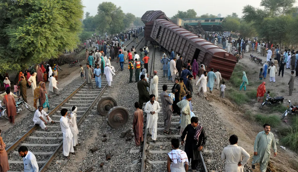 Warga berkumpul di lokasi tabrakan dua kereta api di Multan, Pakistan, Kamis (15/9). Tabrakan terjadi antara rangkaian Kereta Awam Express tujuan Karachi menabrak kereta kargo sekitar 25 kilometer dari Kota Multan. (REUTERS/Khalid Chaudry)