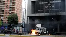 Suasana kerusuhan di depan Gedung Pengadilan Tinggi Venezuela menuntut Presiden Nicolas Maduro di Caracas (7/6).  Para demonstran menghancurkan dan membakar sebuah kendaraan yang terparkir di depan gedung. (Reuters/Carlos Garcia Rawlins)