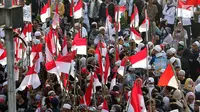 Peserta aksi massa Gerakan Nasional Kedaulatan Rakyat mengibarkan bendera Merah Putih saat melakukan unjuk rasa di depan Gedung Bawaslu, Jakarta, Selasa (21/5/2019). Mereka menolak hasil Pemilu 2019 yang dinilai banyak terdaopat kecurangan. (Liputan6.com/Helmi Fithriansyah)