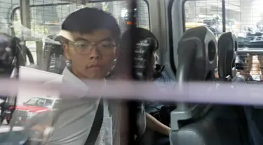Aktivis pro-demokrasi Joshua Wong (kiri) dan Agnes Chow berada di dalam mobil van polisi di pengadilan distrik di Hong Kong, Jumat (30/8/2019). Polisi Hong Kong menangkap aktivis terkenal Wong dan Chow, anggota inti lainnya dari kelompok pro-demokrasi. (AP Photo/Kin Cheung)