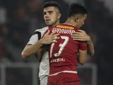 Bek Madura United, Fabiano Beltrame, menghibur bek Persija Jakarta, Gunawan Dwi Cahyo, usai laga Liga 1 di SUGBK, Jakarta, Sabtu (12/5/2018). Persija kalah 0-2 dari Madura United. (Bola.com/Vitalis Yogi Trisna)