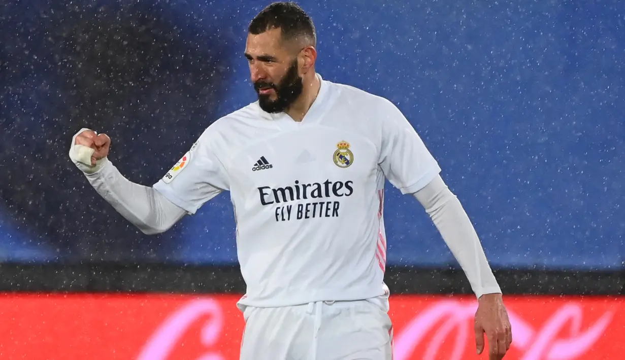 Penyerang Real Madrid, Karim Benzema berselebrasi usai mencetak gol ke gawang Getafe pada pertandingan lanjutan La Liga Spanyol di stadion Alfredo di Stefano di Madrid, Spanyol, Rabu (10/2/2021). EL Real kini mendekati posisi tim tetangga, Atletico Madrid. (AFP/Gabriel Bouys)