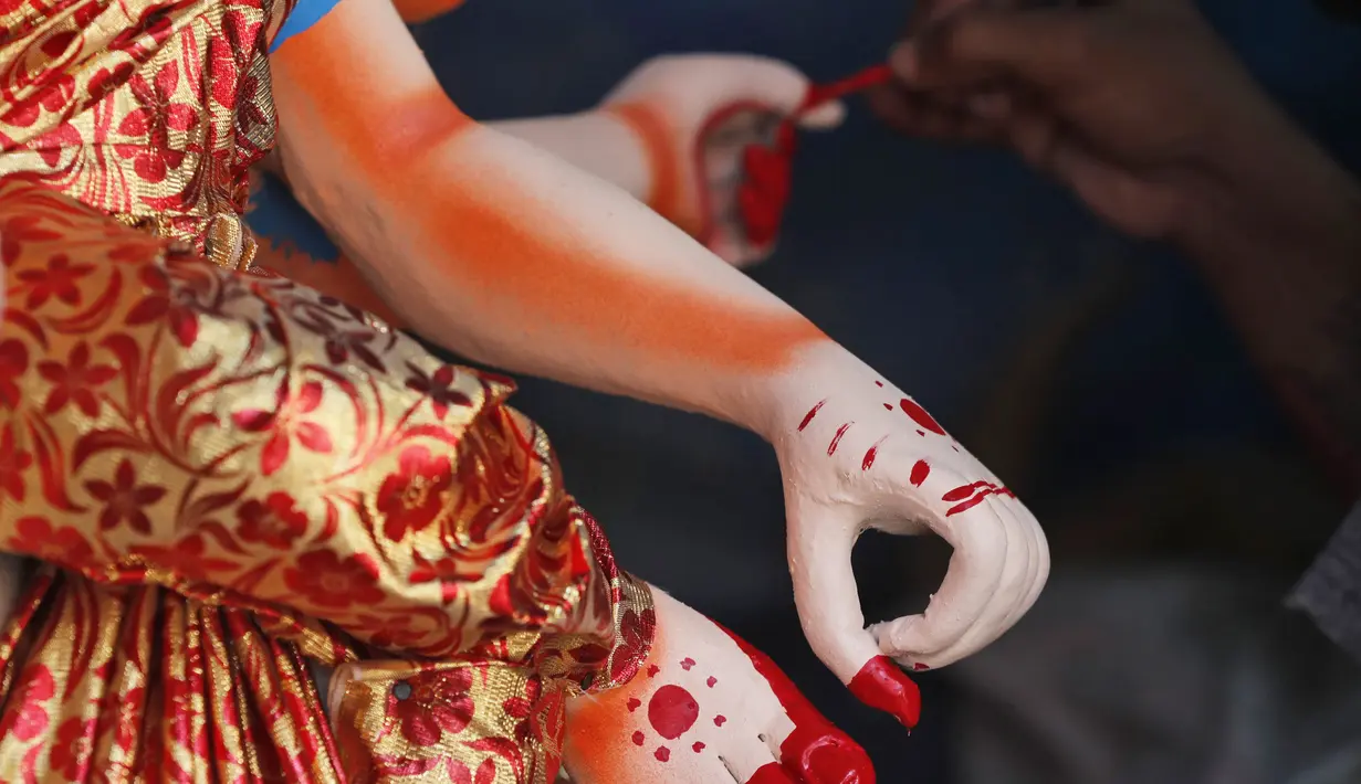 Pematung Nepal Shyam Pandit memberikan sentuhan akhir pada patung dewi Hindu Durga menjelang festival Dashain di Kathmandu, Nepal (14/10/2020). (AP Photo/Niranjan Shrestha)