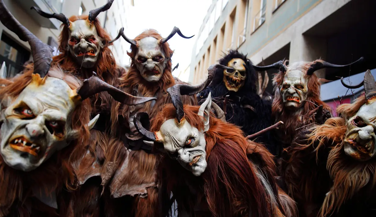 Sejumlah orang berkostum Krampuss selama parade di Munich, Jerman, Minggu (13/12). Dalam ceritanya Krampuss biasanya membawa cambuk hingga lonceng besar untuk menakut-nakuti anak-anak. (REUTERS/Michael Dalder)