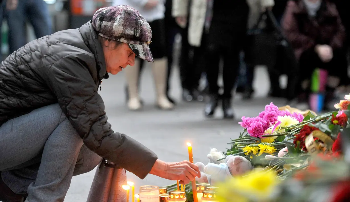 Seorang wanita menaruh lilin di depan Bandara Internasional St. Petersburg di Rusia, Minggu (1/11). ini sebagai bentuk penghormatan kepada para penumpang yang menjadi korban jatuhnya pesawat Kogalymavia di Mesir. (AFP PHOTO/OLGA MALTSEVA)