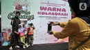 Warga berfoto saat mengunjungi Festival Condet 2022 di Lapangan Gedong, Condet Raya, Jakarta Timur, Minggu (4/9/2022). Selain UMKM kuliner dan pakaian Betawi, festival ini juga dimeriahkan dengan berbagai perlombaam seperti adzan, pencak silat, tari, hingga marawis.  (merdeka.com/Iqbal S. Nugroho)