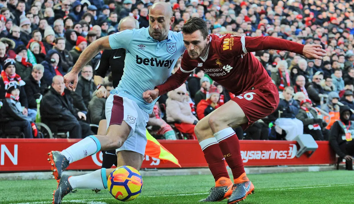 Bek West Ham United, Pablo Zabaleta (kiri) berusaha melewati pemain Liverpool, Andrew Robertson saat bertanding pada lanjutan Liga Inggris di Anfield, Inggris (24/2). Liverpool menang telak atas West Ham 4-1. (AP Photo / Rui Vieira)