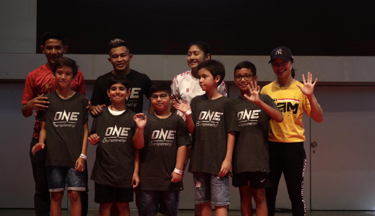 Sejumlah anak-anak berfoto dengan pengisi acara meets and greets ONE Championship dan Timnas Indonesia di Gandaria City Mall, Jakarta, Sabtu (25/1). ONE Championship dan PSSI bersinergi untuk pengembangan atlet di Tanah Air. (Bola.com/Yoppy Renato)
