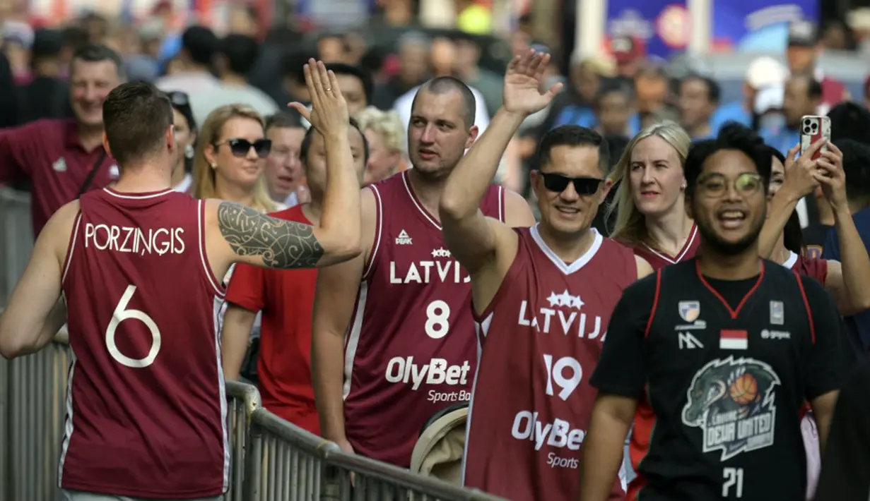 Para suporter Latvia datang mengenakan atribut senada dengan bendera mereka dan banyak pula yang mengenakan aksesoris. (BAY ISMOYO/AFP)