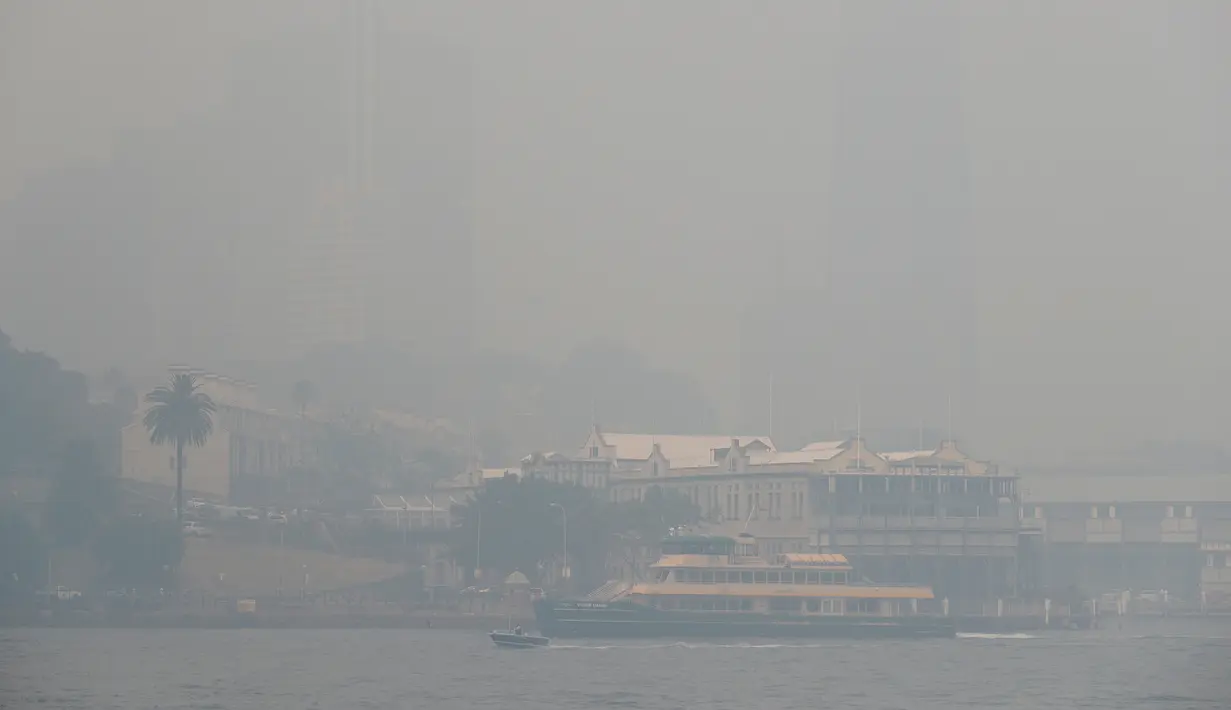 Sebuah kapal feri berlayar di pelabuhan saat kabut asap pekat menyelimuti Sydney, Australia, Selasa (10/12/2019). Kualitas udara di berbagai bagian kota dilaporkan tujuh kali di atas ambang berbahaya. (AP Photo/Rick Rycroft)
