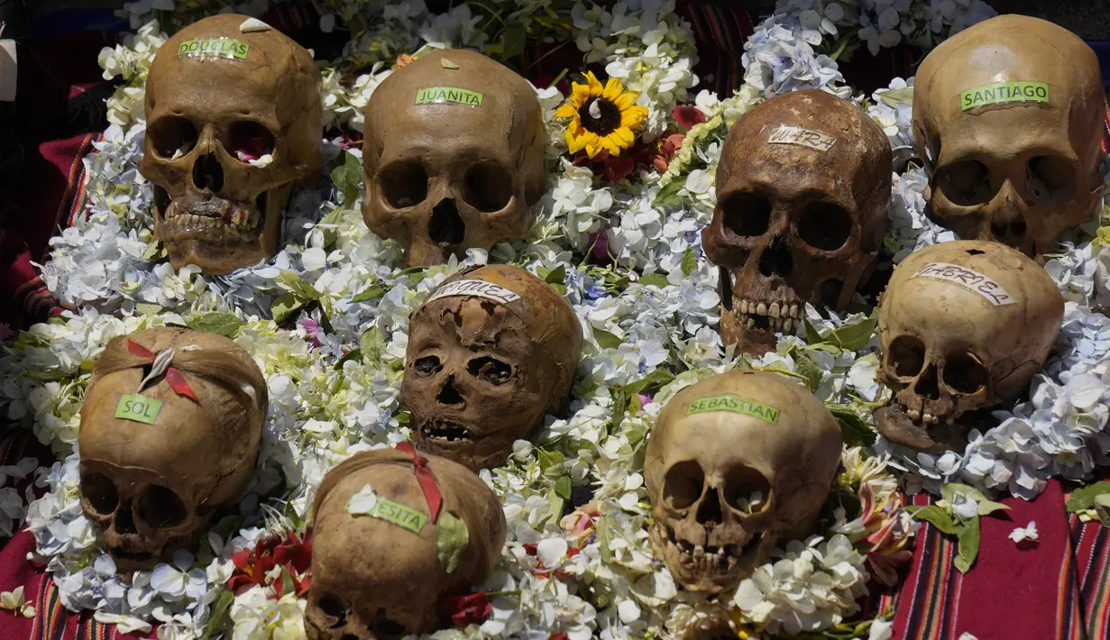 Tengkorak manusia yang dihias dengan label nama dipajang untuk diberkati oleh seorang imam selama Festival Natitas di Pemakaman Umum di La Paz, Bolivia, Selasa (8/11/2022). Tradisi tahunan ini merayakan kematian di Bolivia dengan tengkorak yang dirawat dan didekorasi oleh mereka yang menggunakannya sebagai jimat untuk perlindungan. (AP Photo/Juan Karita)