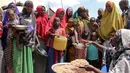 Warga Somalia mengantre untuk mendapat makanan di kamp pengungsian sementara di daerah Tabelaha di pinggiran Mogadishu, Somalia (30/3). Kekeringan ini mengancam setengah dari penduduk negara Somalia. (AP Photo/Farah Abdi Warsameh)