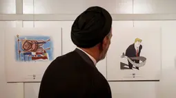 Ulama reformis Iran Mahmoud Doaei melihat kartun Presiden AS Donald J. Trump di sebuah pameran kartun Trumpisme dan karikatur trah Islam tahun 2017, di ibukota Teheran, Iran (3/7). (AFP Photo/Atta Kenare)